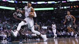 Pebasket Boston Celtics, Jayson Tatum, berusaha melewati hadangan pebasket Milwaukee Bucks, Tony Snell, pada laga NBA di TD Garden, Boston, Rabu (18/10/2017). Celtics kalah 100-108 dari Bucks. (AP/Charles Krupa)