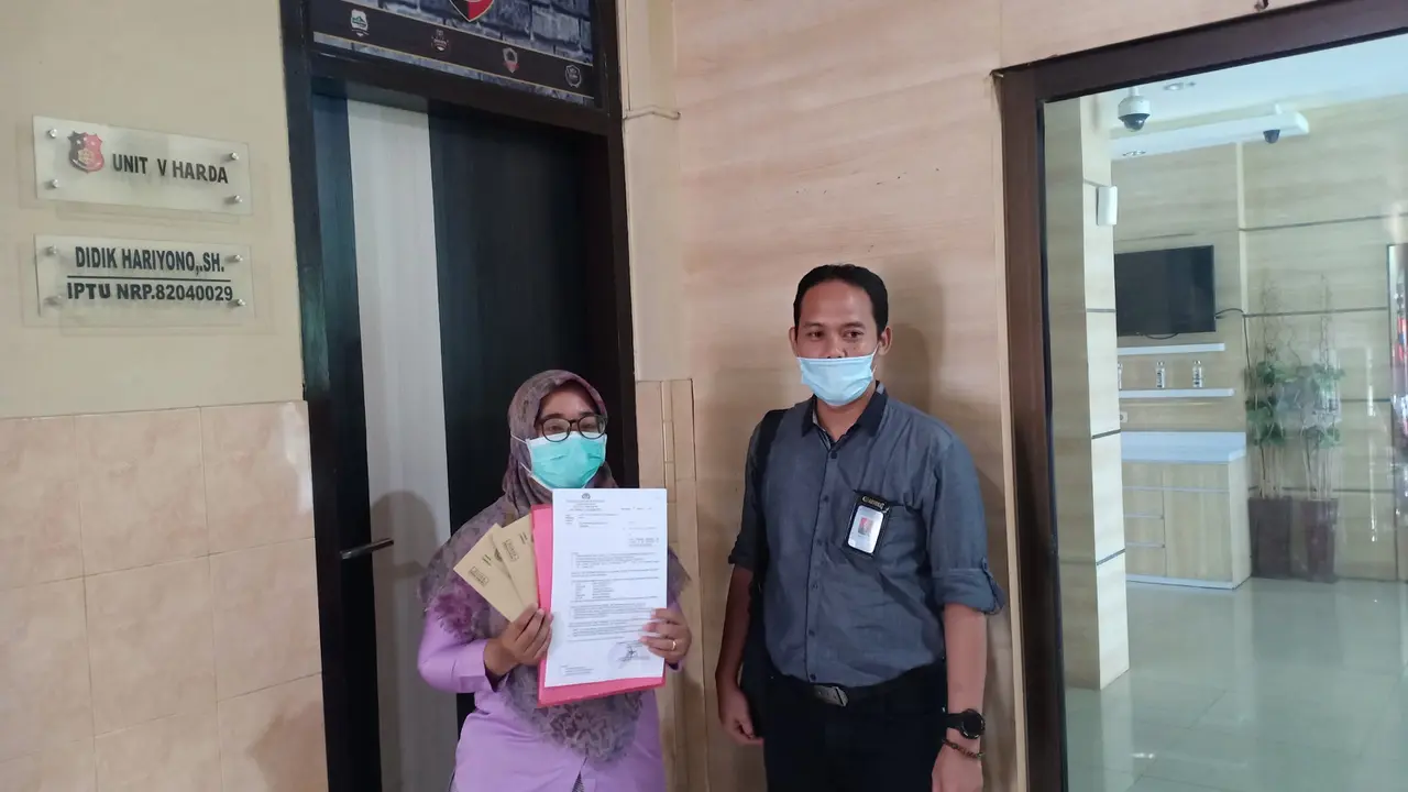 PA (kanan) didampingi kuasa hukumnya M Firdaus Yulianto melaporkan dugaan penipuan ke Mapolresta Banyuwangi. (Istimewa)