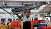 Pedagang membawa ikan di Pasar Ikan Modern (PIM) Muara Baru, Jakarta, Kamis (21/2). PIM Muara Baru mulai ditempati pedagang yang sebelumnya berjualan di Pasar Pelelangan Ikan (PPI). (Merdeka.com/Iqbal Nugroho)