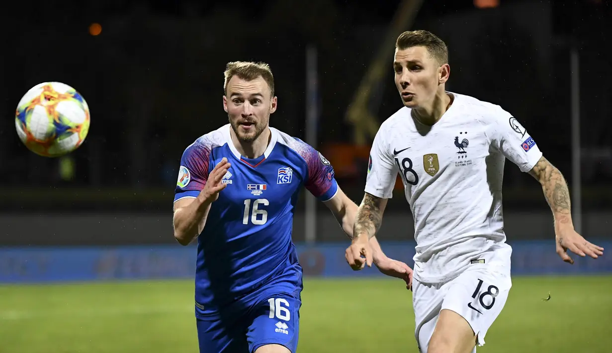 Gelandang Islandia, Runar Mar Sigurjonsson, beradu cepat dengan bek Prancis, Lucas Digne, pada laga Kualifikasi Piala Eropa 2020 di Reykjavik, Sabtu (11/10). Islandia kalah 0-1 dari Prancis. (AFP/Jonathan Nackstrand)