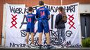 Fans menggunakan jesrsey nomor 34 milik Abdelhak Nouri berdiri di depan spanduk dukungan di Amsterdam, Kamis (13/7/2017). Pemain berusia 20 tahun ini terancam harus mengakhiri kariernya karena mengalami kerusakan otak permanen. (AFP/Bart Maat)