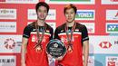 Ganda putra Kevin Sanjaya/Marcus Fernaldi Gideon berpose dengan trofi usai bertanding melawan  Hendra Setiawan / Mohammad Ahsan pada babak fina Jepang Terbuka 2019 di Tokyo (28/7/2019). Kevin / Marcus menang  21-19 dan 23-21.  (AFP Photo/Charly Triballeau)