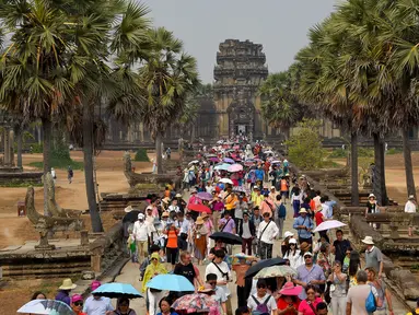 Turis mengunjungi candi Angkor Wat di provinsi Siem Reap, barat laut Kamboja pada 16 Maret 2019. Angkor Wat merupakan salah satu obyek wisata favorit dunia yang dibangun pada abad ke-12 Masehi. (TANG CHHIN Sothy / AFP)