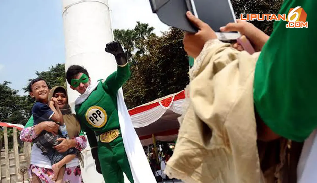  Seorang bocah terlihat gembira saat berfoto bersama Rohman (Super hero PPP) di Tugu Proklamasi Jakarta pada Sabtu (5/04/14) (Liputan6.com/Helmi Fithriansyah)