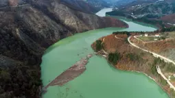 Pemandangan udara dari berton-ton sampah yang mengapung di Sungai Lim dekat Priboj, Serbia, 30 Januari 2023. Botol plastik, papan kayu, tong berkarat, dan sampah lainnya dari tempat pembuangan sampah tepi sungai yang tidak diatur dengan baik terakumulasi selama air pasang. (AP Photo/Armin Durgut)