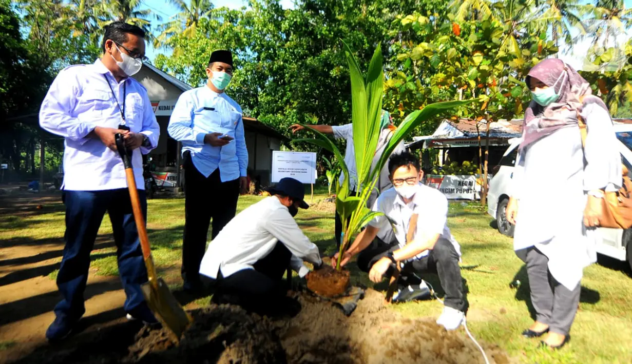 Corporate Secretary Bank BTN Ari Kurniaman (kedua kanan) didampingi Kepala Cabang Bank BTN Kota Padang Yudha Andaka, pejabat daerah Provinsi Sumbar dan Kota Padang saat penanaman bibit pohon kelapa hibrida pandan wangi di Pantai Air Manis, Kota Padang, (7/01/2022). (Liputan6.com/HO/BTN)