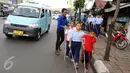 Guru membimbing siswa PSBN Cahaya Bathin penyandang tunanetra mengikuti praktik orientasi mobilitas di Cawang, Jakarta, Selasa (11/4). Praktik itu untuk melatih kemandirian siswa menghadapi situasi apapun dalam kesehariannya. (Liputan6.com/Gempur M Surya)