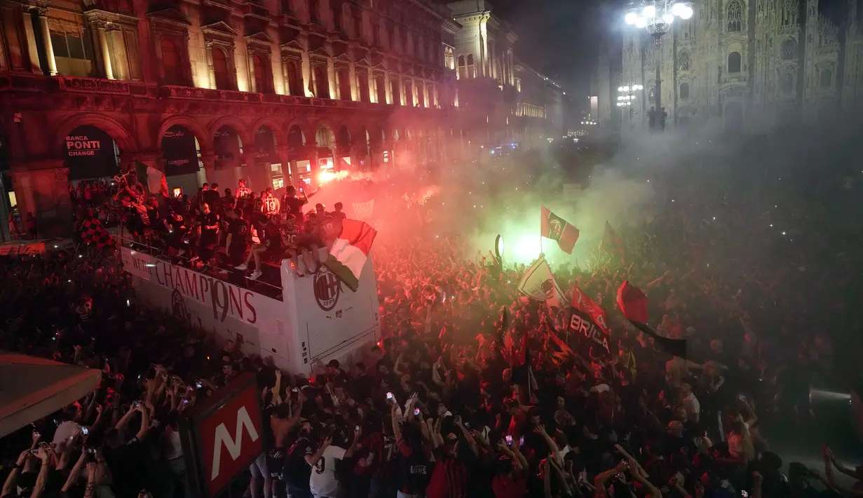 Ribuan penggemar bersorak saat bus yang membawa para pemain tim sepak bola AC Milan melakukan parade kemenangan Liga Italia di depan Katedral Gotik Milan, Milan, Italia, 23 Mei 2022. (AP Photo/Luca Bruno)