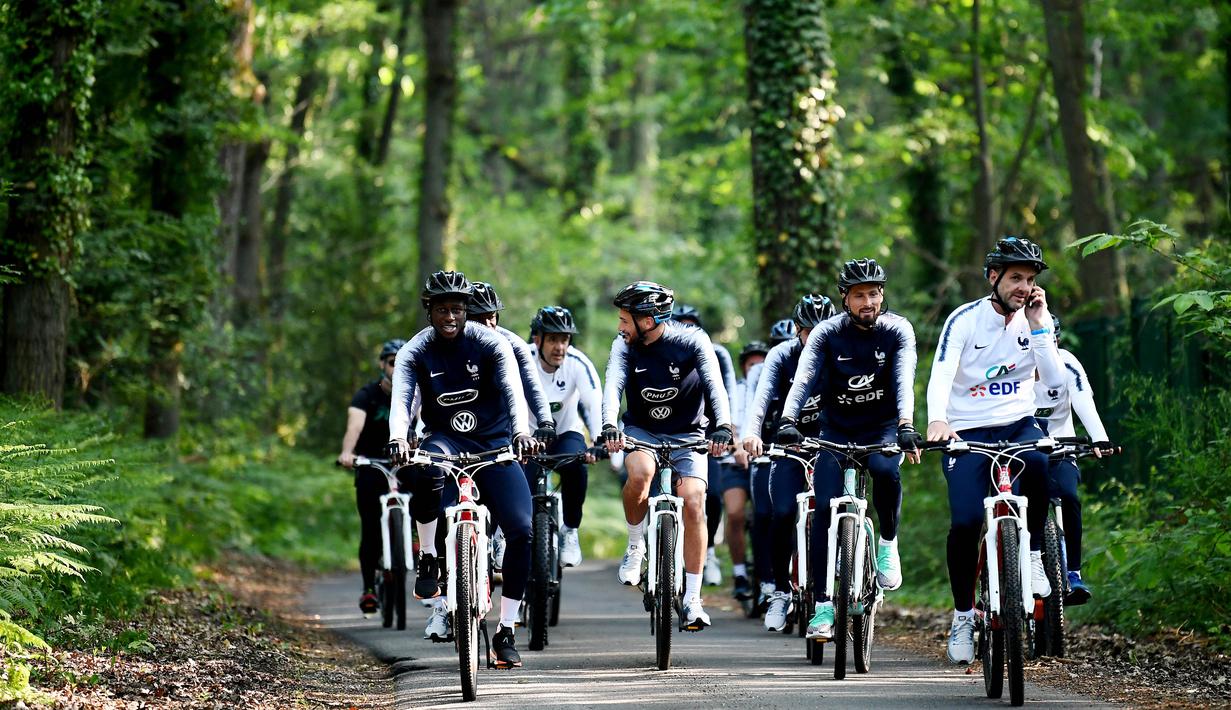 Para pemain Prancis bersepeda di sekitar markas latihan Les Blues di Clairefontaine, Rabu (23/5/2018). Bersepeda merupakan salah satu menu latihan untuk meningkatan kebugaran jelang Piala Dunia 2018. (AFP/Franck Fife)