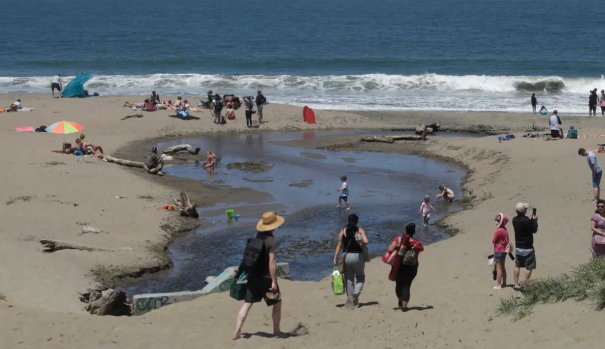 Orang-orang mengunjungi Pantai Baker selama masa pandemi covid-19 di San Francisco pada Minggu (24/5/2020). Warga Amerika Serikat mengabaikan pedoman jarak sosial dan memilih berjemur di pantai ketika angka kematian akibat virus corona di negara itu mendekati 100.000 orang. (AP/Jeff Chiu)