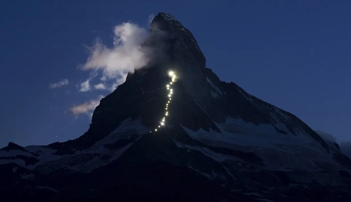 Cahaya lampu terlihat dari kejauhan di puncak gunung Matterhorn, Zermatt, Swiss, Senin (13/7/2015). Lebih dari 500 orang telah tewas, saat berusaha menaklukan gunung ini. Zermatt, Swiss, 13 Juli 2015. (REUTERS/Denis Balibouse)
