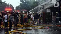 Petugas pemadam kebakaran berusaha memadamkan api yang membakar rumah tinggal di Jalan Dr Saharjo Menteng Atas, Manggarai, Jakarta, Kamis (11/1/2024). Sebanyak 27 unit mobil pemadam dan 100 personel diterjunkan ke lokasi kebakaran. (merdeka.com/Imam Buhori)