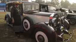 Seorang wanita berpose disamping sebuah mobil antik selama acara Reli Mobil Antik Statesman (Statesman Vintage Car Rally) di Kolkata, India (19/1/2020). Lebih dari 180 mobil dan kendaraan roda dua antik ambil bagian dalam reli mobil klasik dan antik pada acara tersebut. (Xinhua/Tumpa Mondal)