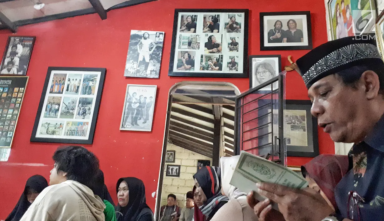 Pelayat berdoa dekat sejumlah foto pentolan Koes Plus, Yon Koeswoyo yang terpajang di kediamannya kawasan Pamulang, Jumat (5/1). Yon merupakan satu-satunya keluarga Koeswoyo yang masih aktif bermusik hingga akhir hayatnya. (Liputan6.com/Fery Pradolo)