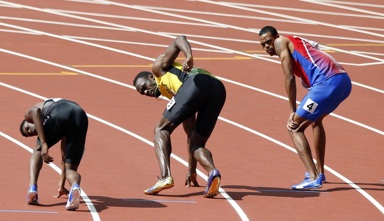 Ekspresi pelari asal Jamaika, Usain Bolt (tengah) dan dua pelari lainya saat berlaga pada nomor lari estafet 4x100m putra di World Athletics Championships, London (12/8/2017). (AP/Alastair Grant)
