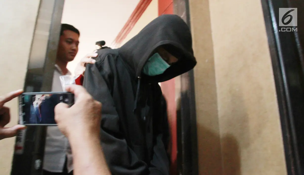 Petugas memberikan keterangan kepada awak media terkait kasus hoax pria IB alias Ismail setelah ia memposting salah satu video kekerasan yang sudah ditambah bahwa itu merupakan kekerasan yang dilakukan Kepolisian saat rilis di Polda Gorontalo, Selasa (28/5/2019). Liputan6.com/Arfandi Ibrahim)