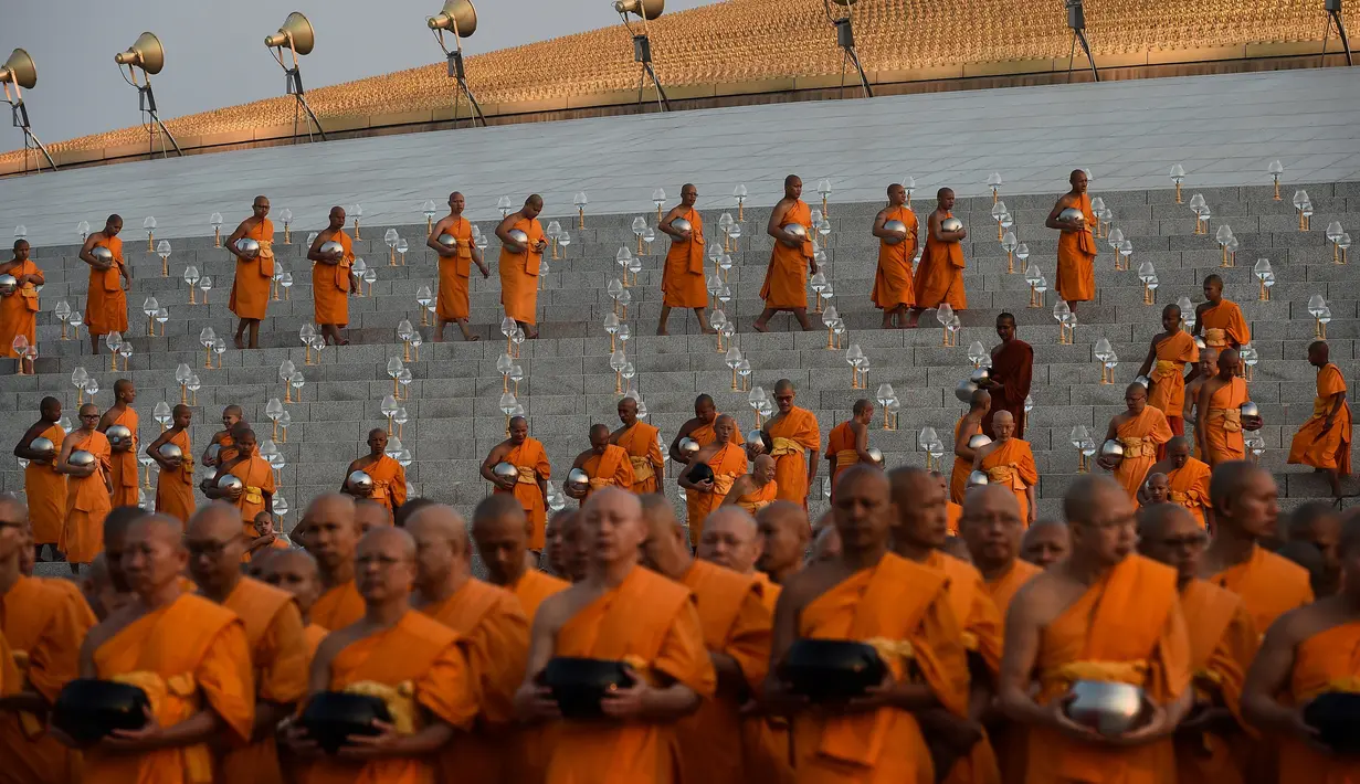 Sejumlah biksu berbaris untuk menerima sedekah usai melakukan ritual Makha Bucha Day di kuil Wat Dhammakaya, Bangkok, Thailand (11/2). (AFP/Lillian Suwanrumpha)