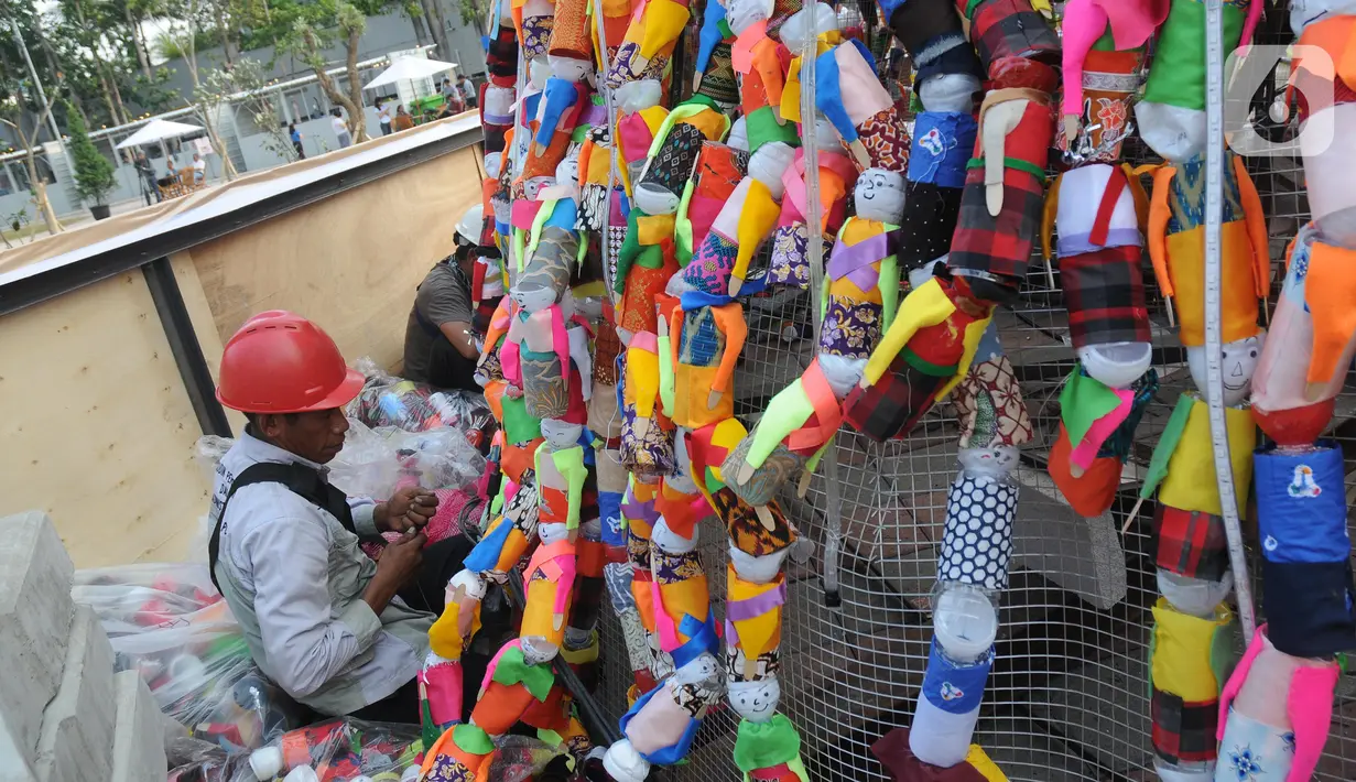 Petugas merapikan miniatur ondel-ondel dari botol minuman bekas yang membentuk Pohon Natal di Food Court Thamrin 10, Jakarta, Sabtu (21/12/2019). Pemprov DKI Jakarta bersama Keuskupan Agung membangun pohon natal setinggi 11 meter menggunakan 8.000 botol bekas. (Liputan6.com/Helmi Fithriansyah)
