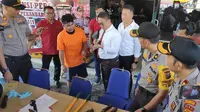 Salah satu tersangka pembobolan minimarket di Pekanbaru menunjukkan ke polisi bagaimana mencongkel gembok. (Liputan6.com/M Syukur)