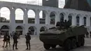 Sebuah mobil baja terlihat saat patroli di lingkungan Lapa di Rio de Janeiro, Brasil, (30/7). Ribuan tentara mulai berpatroli di Rio de Janeiro di tengah lonjakan kekerasan di kota terbesar kedua di Brasil. (AP Photo / Leo Correa)