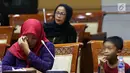 Terpidana kasus pelanggaran UU ITE sekaligus korban pelecehan seksual Baiq Nuril (kiri) menangis saat hadir dalam rapat pleno Komisi III DPR di Gedung Nusantara III, Jakarta, Rabu (23/7/2019). Ibu tiga anak ini tak mau menyerah dan yakin suatu saat keadilan berpihak padanya.(Liputan6.com/JohanTallo)