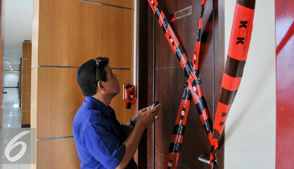 Seorang pria saat berada di depan pintu ruangan Ketua Komisi D DPRD DKI Jakarta, Mohammad Sanusi yang disegel oleh KPK, Jakarta, Jumat (1/4). Sebanyak 4 ruangan di gedung DPRD DKI Jakarta disegel oleh KPK terkait OTT. (Liputan6.com/Yoppy Renato)