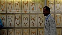 Seorang penjual berjalan melewati kalung emas yang dipajang selama festival Hindu 'Akshaya Tritiya', hari keberuntungan dalam kalender Hindu untuk membeli barang-barang berharga, di ruang pamer perhiasan di Chennai, India, Selasa (3/5/2022). Membeli emas adalah kegiatan yang populer di Akshaya Tritiya, karena ini adalah simbol utama kekayaan dan kemakmuran. (Arun SANKAR / AFP)