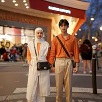 Tampil kompak bareng pasangan, gaya Dinda Hauw dengan cardigan panjang lengan pendek warna putih dan sweater oranye ini bisa kamu jadikan referensi. Tambahkan sling bag biar makin kece! (Instagram/reymbayang).