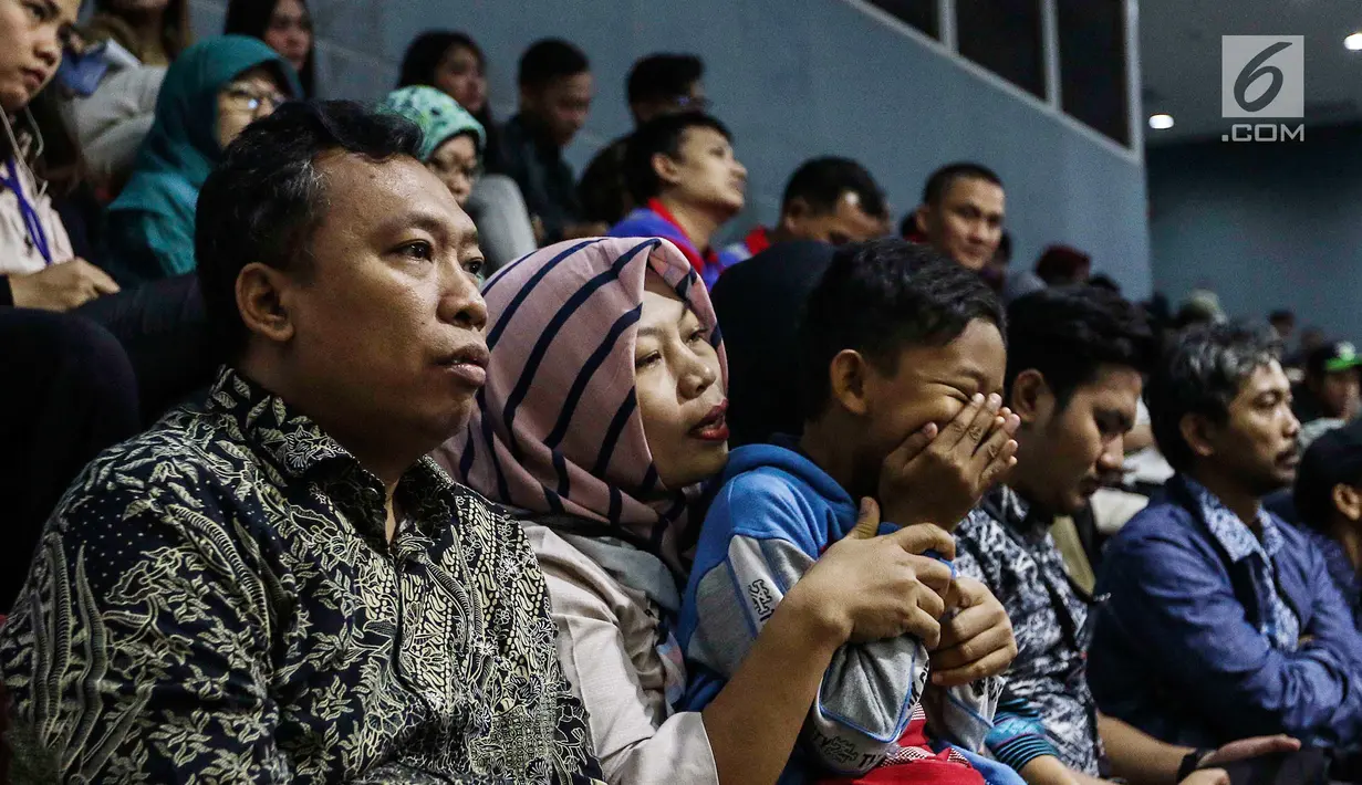 Terpidana kasus dugaan pelanggaran UU ITE sekaligus korban pelecehan seksual Baiq Nuril memangku anaknya saat menghadiri rapat paripurna DPR di Kompleks Parlemen Senayan, Jakarta, Kamis (25/7/2019). Berkali-kali dia memeluk dan mencium putranya. (Liputan6.com/JohanTallo)