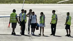 Pemain Argentina, Lionel Messi (kanan) dan Angel Di Maria terlihat berjalan memasuki helikopter saat parade kemenangan Piala Dunia 2022 di provinsi Buenos Aires, pada 20 Desember 2022. Messi dan kolega terpaksa dievakuasi karena bus yang mereka gunakan tak bisa mencapai lokasi yang direncanakan akibat membeludaknya warga di jalanan. (AFP/Matias Baglietto)