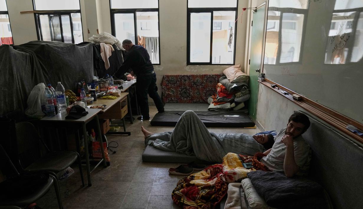 Badan Dunia untuk Anak-Anak (UNICEF), menyebut, serangan udara Israel ke Lebanon yang kian intensif sejak 2 Maret 2026, telah memaksa hampir 700.000 orang, termasuk 200.000 anak, mengungsi. Tampak dalam foto, para pengungsi yang menghindari serangan udara Israel di Lebanon selatan dan Dahiyeh, beristirahat di Institut Teknik Bir Hassan yang telah diubah menjadi tempat penampungan, Beirut, Rabu 11 Maret 2026. (AP Photo/Bilal Hussein)