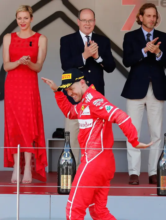 Pembalap Ferrari Sebastian Vettel berselebrasi di atas podium saat merayakan kemenangannya pada balapan GP Monaco di Sirkuit Monte Carlo, Minggu (28/5). Vettel finis pada urutan pertama dengan waktu satu jam 44 menit 44,340 detik (AP Photo/Frank Augstein)