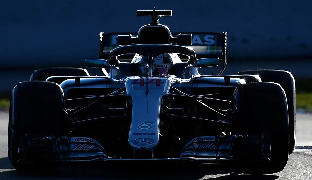 Pembalap Mercedes Lewis Hamilton berada dalam mobilnya saat sesi pengujian pramusim di Sirkuit de Catalunya, Spanyol (6/3). Juara musim lalu ini kembali akan berpasangan dengan pembalap asal Finlandia, Valterri Bottas di Mercedes. (AFP Photo/Lluis Gene)