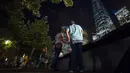 Pejalan kaki menyaksikan keindahan lampu sorot dipancarkan ke langit dari World Trade Center (WTC) kota New York, AS, (9/9/2015). Acara Tribute in Light memperingati 14 tahun tragedi terorisme 11 September di Amerika Serikat. (REUTERS/Andrew Kelly)
