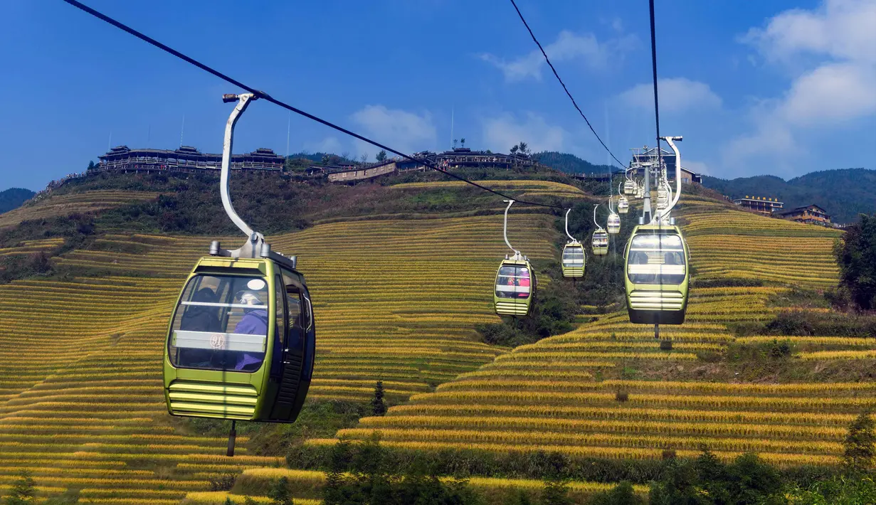 Para wisatawan menaiki kereta gantung untuk melihat pemandangan sawah terasering Longji di Wilayah Longsheng, Daerah Otonom Etnis Zhuang Guangxi, China selatan, pada 12 Oktober 2020. (Xinhua/Wu Shengbin)