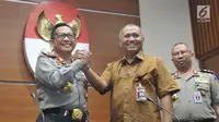 Kapolri Jenderal Tito Karnavian berjabat tangan dengan Pimpinan KPK, Agus Rahardjo saat konfrensi pers membahas penanganan kasus teror terhadap penyidik senior KPK Novel Baswedan, Jakarta, Senin (19/6). (Liputan6.com/Helmi Afandi)