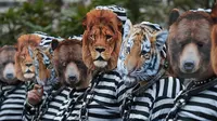 Para pemrotes mengenakan pakaian penjara dan topeng binatang saat melakukan aksinya di Strasbourg, Prancis (12/4). Mereka melakukan aksi untuk menolak penggunaan hewan dalam pertunjukan sirkus. (AFP/Frederick Florin)