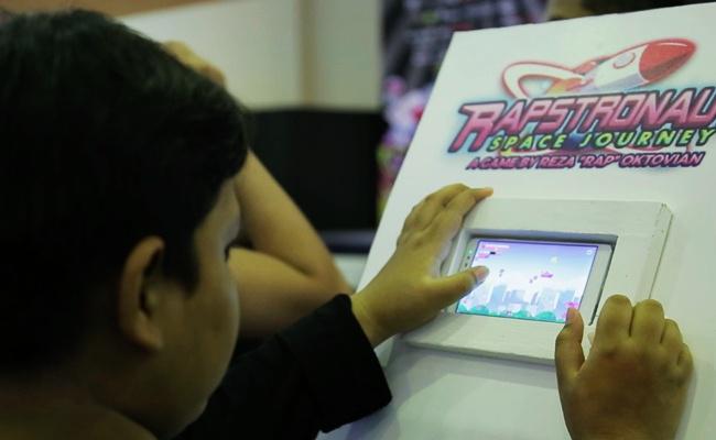Seorang gamer sedang mencoba memainkan game baru dari Reza | Photo: Copyright Doc Vemale.com