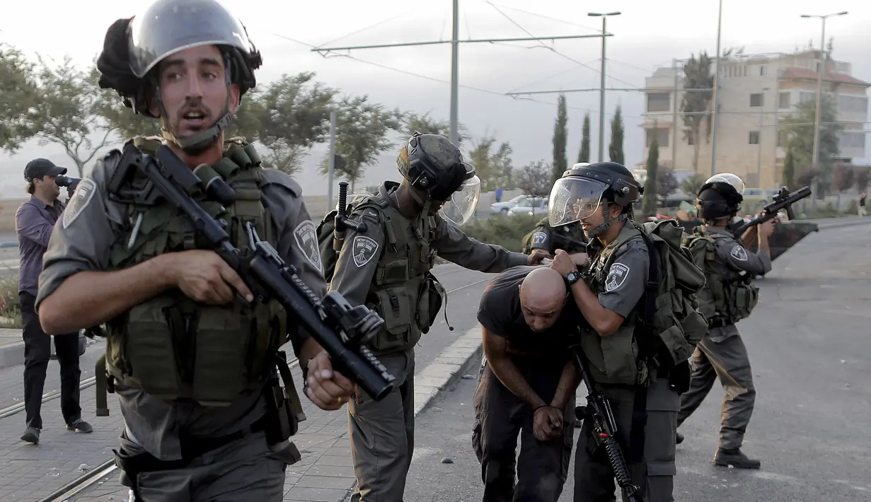 Polisi perbatasan Israel menahan seorang pengunjuk rasa Palestina dalam bentrokan di Shuafat, sebuah daerah pinggiran Arab, Yerusalem, Senin (5/10/2015). Seorang remaja Palestina tewas pada Senin dalam bentrokan di Tepi Barat. (REUTERS/Ammar Awad)
