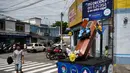 Seorang anak mengamati peti mati dengan tulisan, "Anda memutuskan, di rumah atau di dalam kotak ini", sebagai bagian dari kampanye pemerintah setempat di jalan-jalan kotamadya Escuintla, Guatemala City pada 21 Juli 2020. Kampanye itu upaya untuk menghentikan penyebaran COVID-19. (Johan ORDONEZ/AFP)