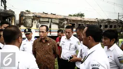 Menhub Budi Karya menggali keterangan dari petugas saat meninjau lokasi terbakarnya dua gerbong kereta Kerta Jaya kelas Ekonomi di dekat Stasiun Tanjung Priok, Jakarta, Kamis (25/8). (Liputan6.com/Faizal Fanani)