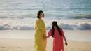 Marsha Timothy tampil dengan dress lengan 3/4 warna hijau bersama putrinya di pantai. @marshatimothy