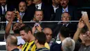 Presiden Turki Recep Tayyip Erdogan (tengah) tersenyum kepada penonton saat menyaksikan pertandingan putaran ketiga kualifikasi UEFA Europa League antara Fenerbahce dan Sturm Graz di Stadion Ulker Fenerbahce di Istanbul (3/8). (AFP Photo/Ozan Kose)