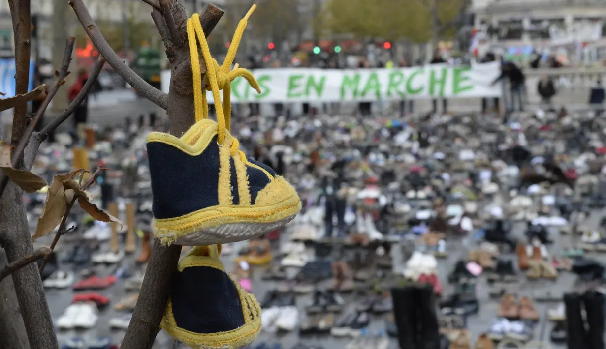 Place de la Republique, Prancis, ditutupi ribuan pasang sepatu yang dikirimkan para aktivis sebagai tanda solidaritas karena pawai lingkungan di Paris dibatalkan jelang Konferensi Tingkat Tinggi Perubahan Iklim, Minggu (29/11).  (AFP PHOTO/Miguel Medina)