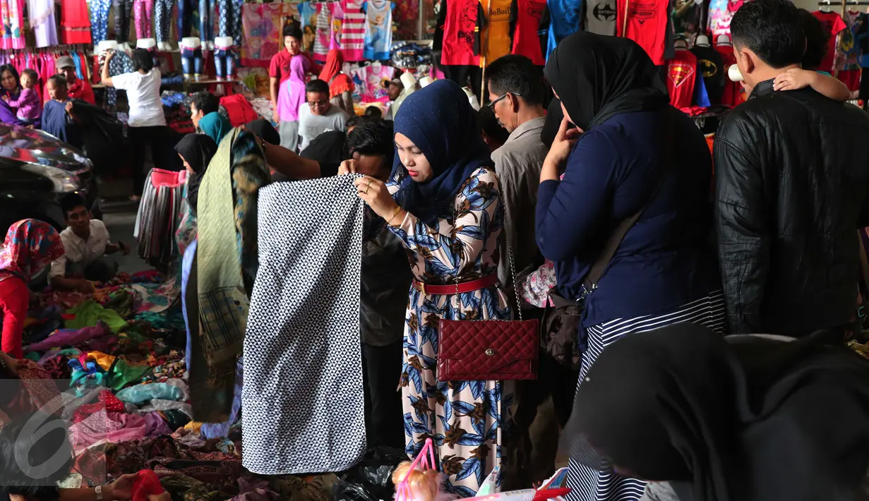 Calon pembeli memilih kerudung saat berbelanja di Pasar Tanah Abang, Jakarta, Rabu (9/12). Libur pilkada dimanfaatkan warga untuk berbelanja pakaian di pasar tekstil terbesar di Asia Tenggara itu. (Liputan6.com/Angga Yuniar)