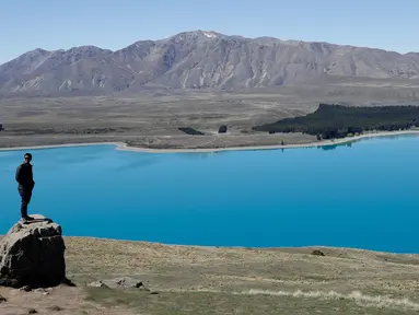 Turis berpose di Observatorium Mount John di Danau Tekapo, Selandia Baru (6/10). Danau ini terbesar kedua dari tiga danau paralel di utara-selatan sepanjang tepi utara Lembah Sungai Mackenzie di Pulau Selatan Selandia Baru. (AP Photo/Mark Baker)