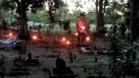 Salah satu warga Kampung Tua di Pulau Rempang menyalakan obor di pemakaman nenek moyang mereka, sekaligus sebagai pengingat bahwa warga sudah menghuni Rempang sejak Indonesia belum lahir. Foto: liputan6.com/ajang nurdin&nbsp;