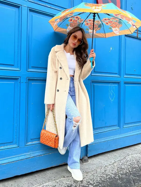 <p>Top putih dan coat panjangmu juga bisa dipasangkan dengan baggy jeans. Seperti outift Cinta Laura ini. (sumber : Instagram @calurakiehl)</p>