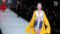 Seorang model berjalan diatas catwalk membawakan rancangan karya Paulina Katarina dalam Jakarta Fashion Week 2018 di Senayan City, Jakarta, Kamis (26/10). Rancangan ini terinspirasi dari kain tradisional khas bali. (Liputan6.com/Faizal Fanani)