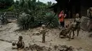 Kondisi lingkungan dan sanitasi yang kurang memadai pasca- bencana dapat memicu peningkatan kasus Infeksi Saluran Pernapasan Akut (ISPA), seperti batuk, pilek, hingga demam. Tampak dalam foto, anak-anak bermain di genangan lumpur di Pengidam, Aceh Tamiang, pada Senin 15 Desember 2025. (Yasuyoshi Chiba/AFP)